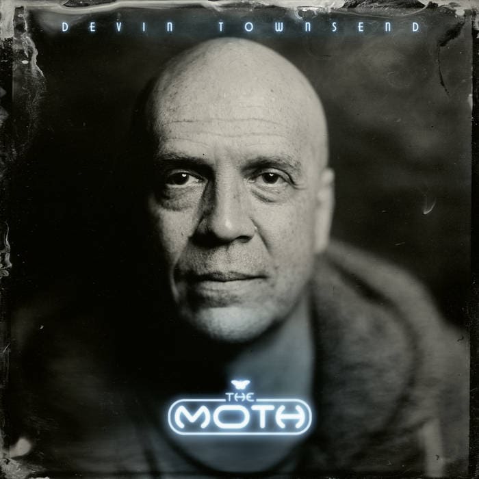 Black-and-white close-up portrait of a bald man with a serious expression; neon 'The Moth' logo glows at the bottom, on an album cover.