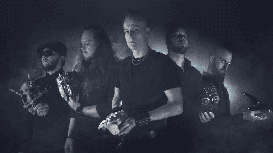 Five men in black attire stand in a smoky, moody studio; the central figure holds a pale mask.
