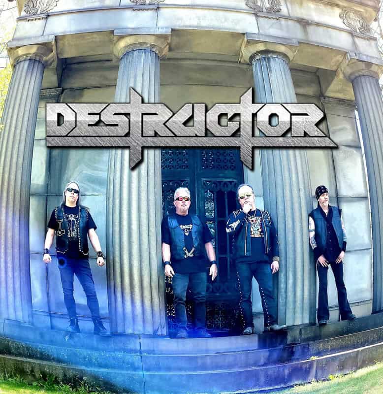 Four-member heavy metal band posing in front of a stone colonnade, with a large 'DESTRUKTOR' logo above them.