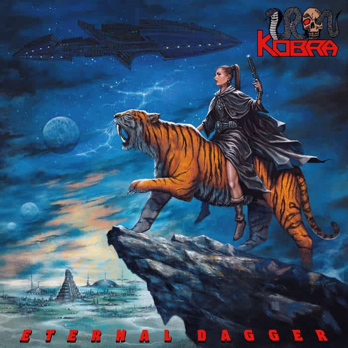 Heroine in a dark cape rides a roaring orange tiger along a rocky ledge, with a sci-fi city and starship in the sky; 'ETERNAL DAGGER' at the bottom and a Kobra logo top-right.
