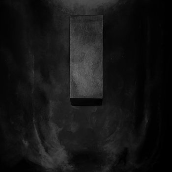 A tall, dark rectangular block centered against a black, smoky textured background.