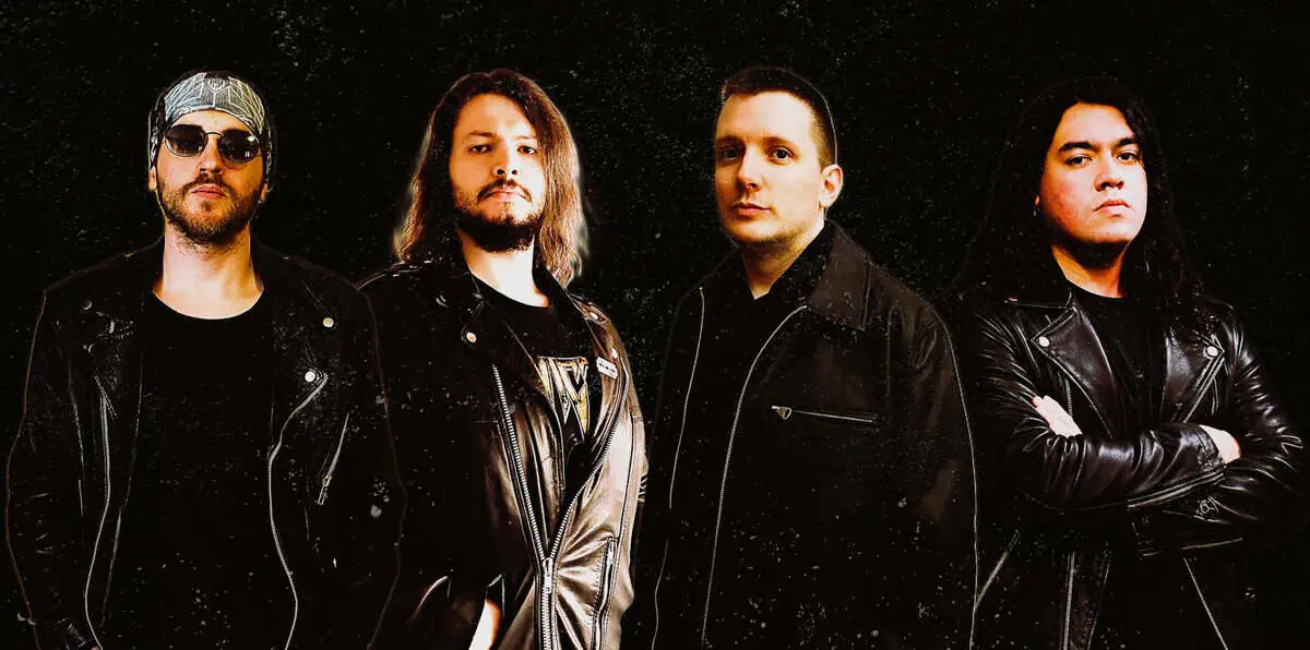 Four men in black leather jackets stand together for a band photo against a dark speckled background.